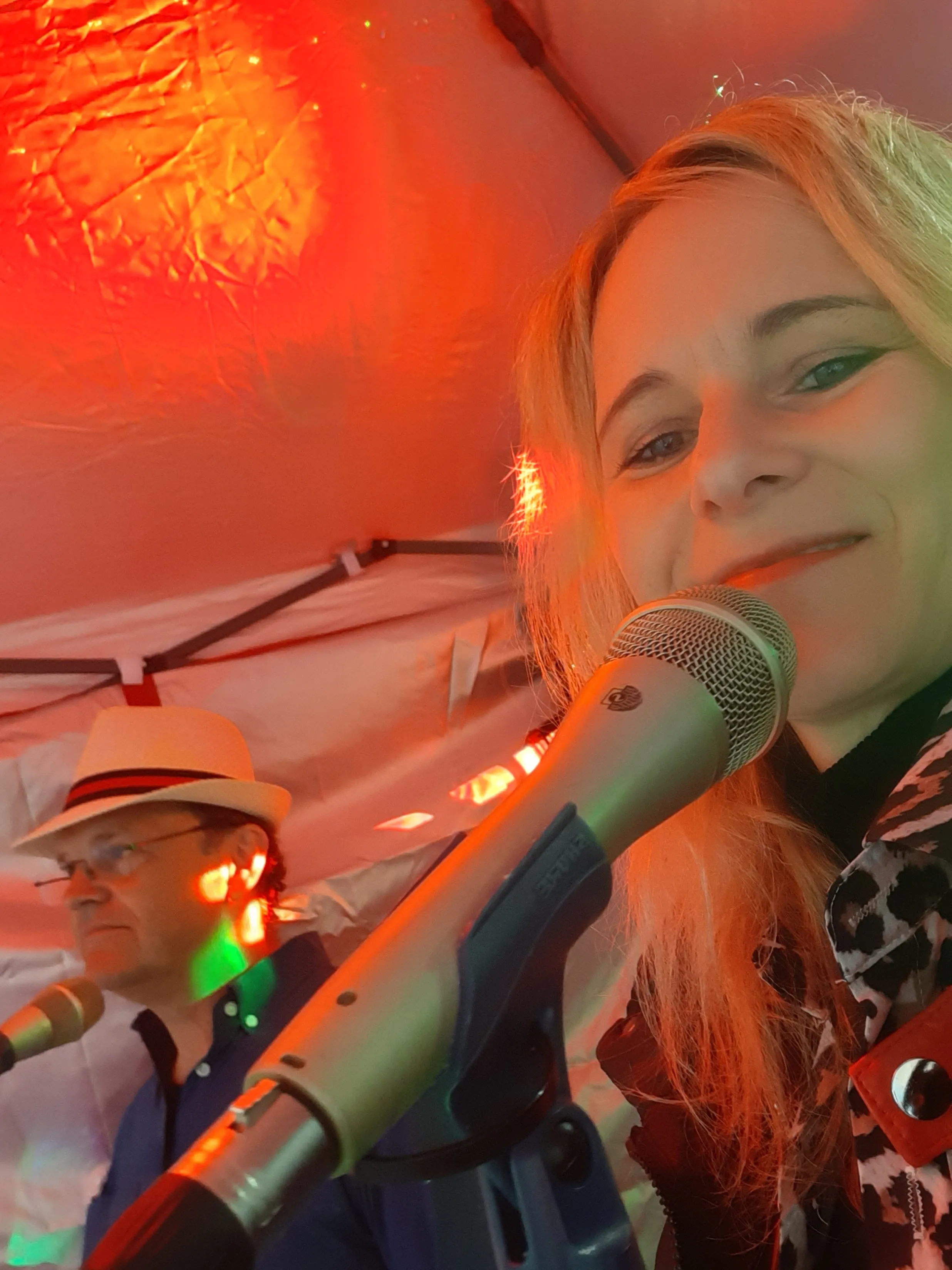 Susanne singt live am Mikrofon, im Hintergrund ihr Duo-Partner
