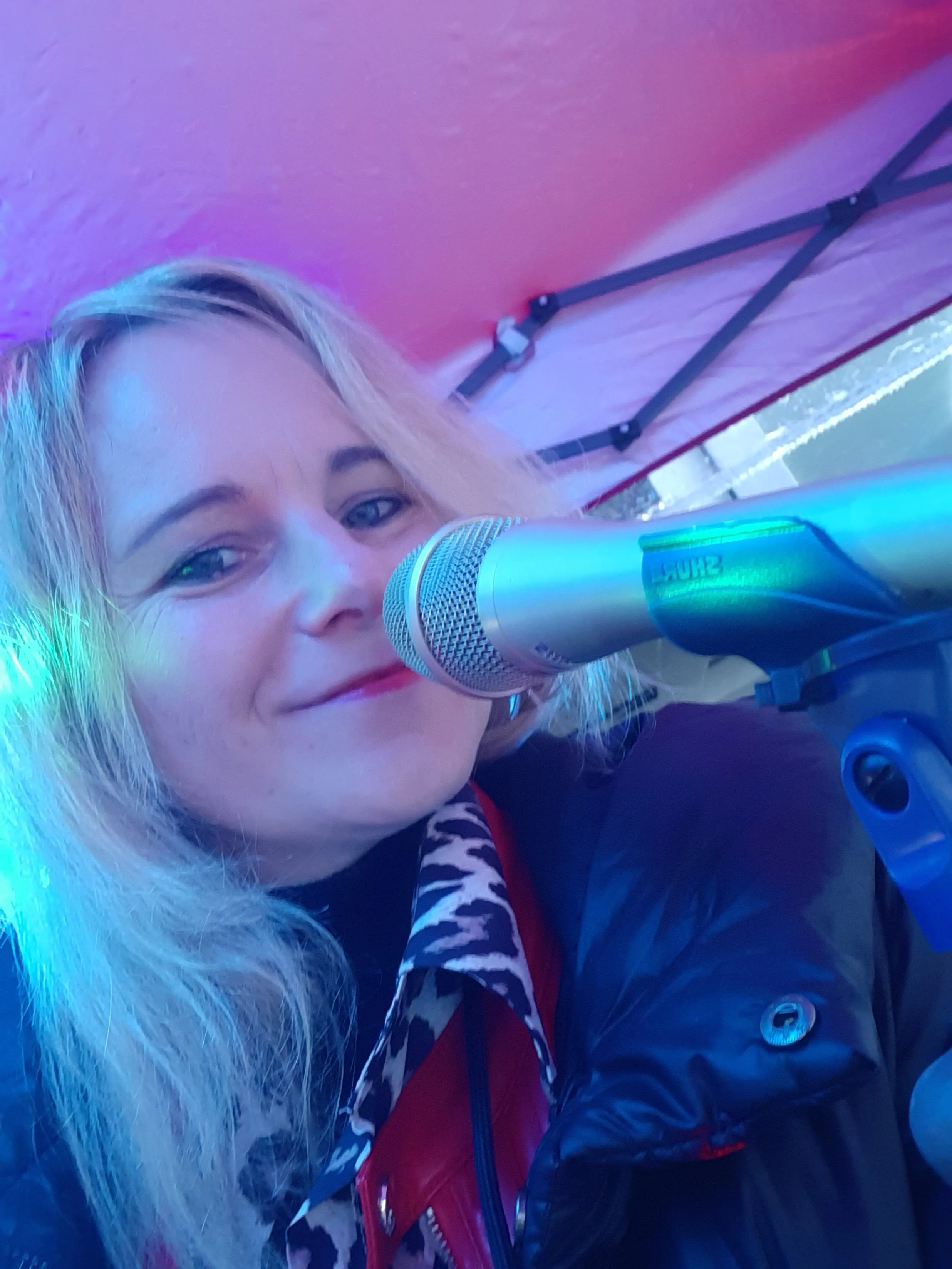 Susanne lächelnd am Mikrofon während eines Auftritts